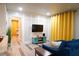 Spacious living area with blue couch, tv, accent table, and open view to hallway and bedroom at 1452 Mercer Ave, Atlanta, GA 30337
