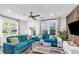 Bright living room featuring hardwood floors, blue couches, large windows, and a ceiling fan at 1452 Mercer Ave, Atlanta, GA 30337