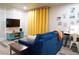 Cozy living room with blue sofa, yellow curtains, wall decor, and a functional workspace at 1452 Mercer Ave, Atlanta, GA 30337
