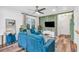 Open-concept living room featuring hardwood floors, blue couches, large windows, and a ceiling fan at 1452 Mercer Ave, Atlanta, GA 30337