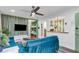Open-concept living room featuring hardwood floors, blue couches, large windows, and a ceiling fan at 1452 Mercer Ave, Atlanta, GA 30337