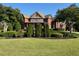 Expansive brick home with manicured landscaping, mature trees, and lush green lawn at 692 Heritage Post Ln, Grayson, GA 30017