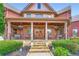Charming covered front porch with double doors, stone steps, and wrought iron railings at 692 Heritage Post Ln, Grayson, GA 30017