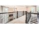 Second story hallway with wrought iron railing overlooking a fireplace, and carpet flooring at 692 Heritage Post Ln, Grayson, GA 30017