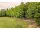 A view of a large grass-filled yard and a long, wooden fence bordering a property line at 7 Perkins Mountain Rd, Kingston, GA 30145
