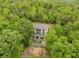 A rear view of the home surrounded by dense foliage showing a multi-story rear deck or patio at 7 Perkins Mountain Rd, Kingston, GA 30145