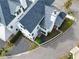 Aerial view of a new home's gray roof, manicured garden, sidewalks, and newly installed driveway at 11530 Serenbe Ln, Chattahoochee Hills, GA 30268