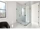 Bright bathroom features a glass shower with white marble surround and floors, plus a black window frame at 11530 Serenbe Ln, Chattahoochee Hills, GA 30268