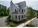 New construction with black windows, covered porch, lush landscaping, and a three-car garage at 11530 Serenbe Ln, Chattahoochee Hills, GA 30268