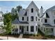Charming exterior showcasing a two-story white home with a covered porch and elegant architectural details at 11530 Serenbe Ln, Chattahoochee Hills, GA 30268