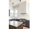 Modern kitchen featuring dark cabinets, stainless steel appliances, and a stylish island at 11530 Serenbe Ln, Chattahoochee Hills, GA 30268