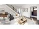 Inviting living room showcasing hardwood floors, contemporary furnishings, and a staircase with iron railing at 11530 Serenbe Ln, Chattahoochee Hills, GA 30268