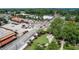 Aerial view of commercial buildings with street traffic, landscaping, and mature trees at 116 Via Roma, Woodstock, GA 30188