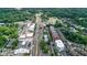 An aerial view of a commercial property and a residential neighborhood surrounded by lush greenery at 116 Via Roma, Woodstock, GA 30188