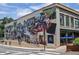 Brick building with a large mural and the Woodstock Health Mart Pharmacy at 116 Via Roma, Woodstock, GA 30188