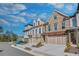 Beautiful townhome exterior with stone and brick accents, a trellised garage and blue sky at 116 Via Roma, Woodstock, GA 30188
