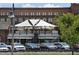 Exterior view of a restaurant with outdoor rooftop seating with a parking lot and trees at 116 Via Roma, Woodstock, GA 30188