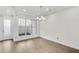 Bright living room features a modern light fixture and large windows that let in natural light at 116 Via Roma, Woodstock, GA 30188