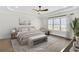 Staged main bedroom featuring a plush bed, tray ceiling, and a large window at 116 Via Roma, Woodstock, GA 30188