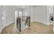 Well-lit staircase landing with wood floors and black iron railing at 116 Via Roma, Woodstock, GA 30188