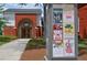 Charming brick theater with a welcoming arched entrance, set amidst a well-maintained lawn and a community billboard at 116 Via Roma, Woodstock, GA 30188