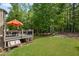 Spacious backyard view from the deck, featuring a bench and mature trees, perfect for enjoying the outdoors at 227 Cedarhurst Dr, Canton, GA 30115
