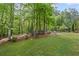 Lush backyard featuring mature trees, garden beds and landscaping providing a private outdoor retreat at 227 Cedarhurst Dr, Canton, GA 30115