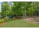 Well-manicured backyard with lush greenery and mature trees, providing a serene outdoor space with a trampoline at 227 Cedarhurst Dr, Canton, GA 30115