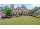 Charming two-story brick home with a manicured lawn and colorful, mature landscaping at 227 Cedarhurst Dr, Canton, GA 30115