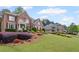 Beautifully landscaped front yard with a stately brick home and lush green lawn at 227 Cedarhurst Dr, Canton, GA 30115