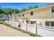 Street view of cozy townhomes featuring yellow siding and quaint, fenced front yards with lush landscaping at 2716 Suwanee Se Way, Marietta, GA 30067