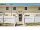 Charming two-story townhome with yellow siding and a white picket fence, creating a welcoming curb appeal at 2716 Suwanee Se Way, Marietta, GA 30067