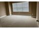 Bright bedroom featuring neutral carpet and a large window offering natural light at 3648 Lake Estates Way, Atlanta, GA 30349