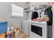 A well lit laundry room features a washer, dryer, storage shelf and a window at 6237 Thorncrest Dr # 10, Tucker, GA 30084