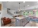 An open concept living room has hardwood floors, with staircase and kitchen island at 6237 Thorncrest Dr # 10, Tucker, GA 30084