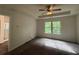Bright main bedroom features a tray ceiling, a ceiling fan, plush carpet, and a large window with a view of the wooded surroundings at 2285 Crossrail Dr, Atlanta, GA 30349