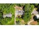 Aerial view of the property, with mature trees, manicured lawn, multiple outbuildings and long driveways at 4281 Chimney Lake Ne Dr, Roswell, GA 30075