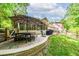 Back patio featuring brick pavers, an outdoor dining table, an umbrella and a grill for entertaining at 4281 Chimney Lake Ne Dr, Roswell, GA 30075