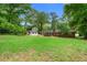 Expansive backyard featuring a lush lawn and mature trees surrounding the brick home at 4356 Executive Dr, Stone Mountain, GA 30083
