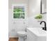 Bathroom with a white toilet, vanity, white tiled wall, and a window at 4356 Executive Dr, Stone Mountain, GA 30083