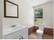 Bathroom featuring a pedestal sink, framed mirror, and tiled floors at 4356 Executive Dr, Stone Mountain, GA 30083