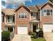 Charming townhome showcasing a brick facade, single-car garage, and neatly landscaped front yard under a bright sky at 5485 Sierra Trl, Atlanta, GA 30349