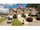 Inviting townhomes with brick and siding exteriors, complemented by lush greenery and a manicured lawn at 5485 Sierra Trl, Atlanta, GA 30349