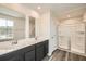 Bathroom featuring double sinks, vanity, large mirror, and a glass-enclosed shower at 8491 Limerick Ln, Winston, GA 30187