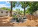 Large, tree-filled backyard featuring a fire pit with chairs and a patio off of the main house at 2342 Eastway Rd, Decatur, GA 30033