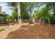 Well maintained backyard with a patio, fire pit, mature trees and a swing set for children at 2342 Eastway Rd, Decatur, GA 30033