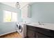 Well-lit laundry room includes a washer, dryer, sink, and upper cabinet storage at 2342 Eastway Rd, Decatur, GA 30033