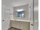 Bright bathroom with a vanity, white cabinets, and a decorative mirror at 2976 Matthew Ln, Lawrenceville, GA 30044