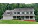 Traditional two-story home with a welcoming front porch, attached garage, and mature trees at 2976 Matthew Ln, Lawrenceville, GA 30044