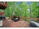 Back deck featuring an outdoor grill and seating surrounded by lush trees at 4514 Creekwood Nw Cir, Kennesaw, GA 30152